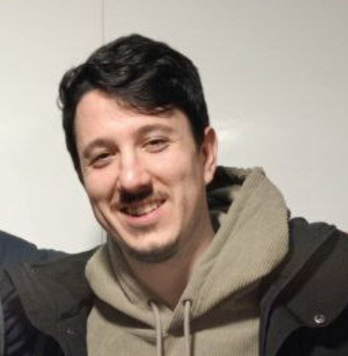 Portrait of a man with glasses wearing a gray shirt.